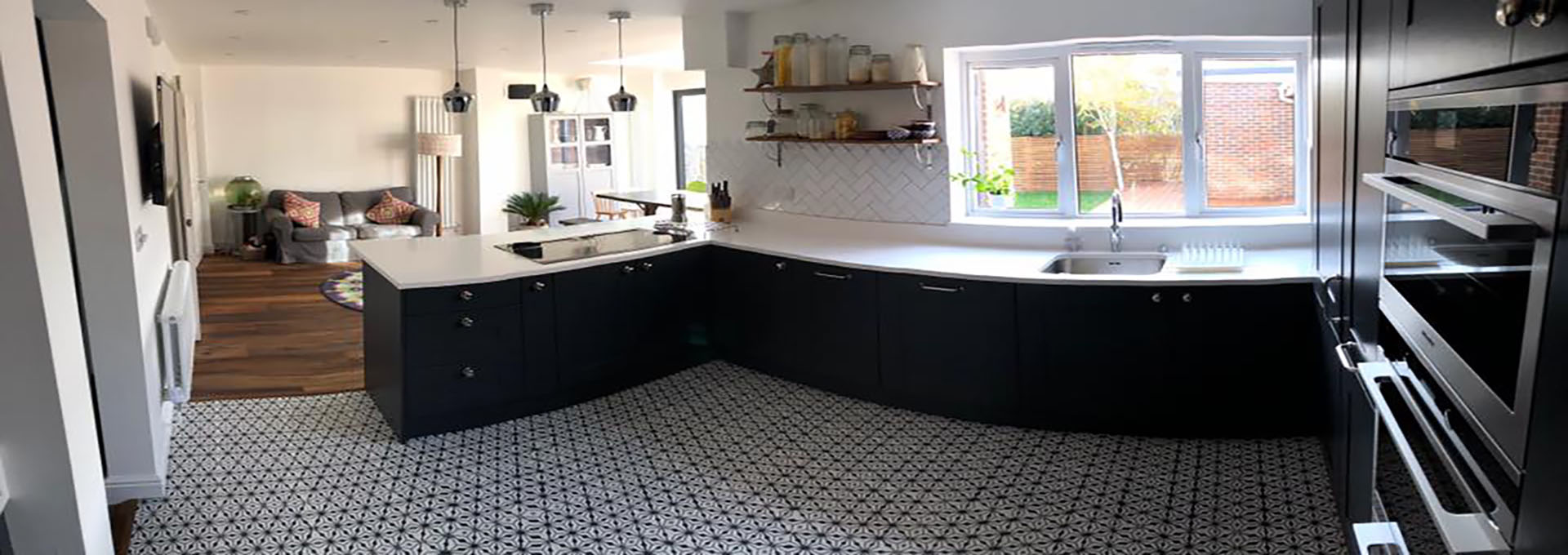 Open-plan kitchen with dark cabinetry and patterned flooring